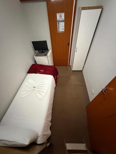 Quarto individual com cama de solteiro, TV e frigobar